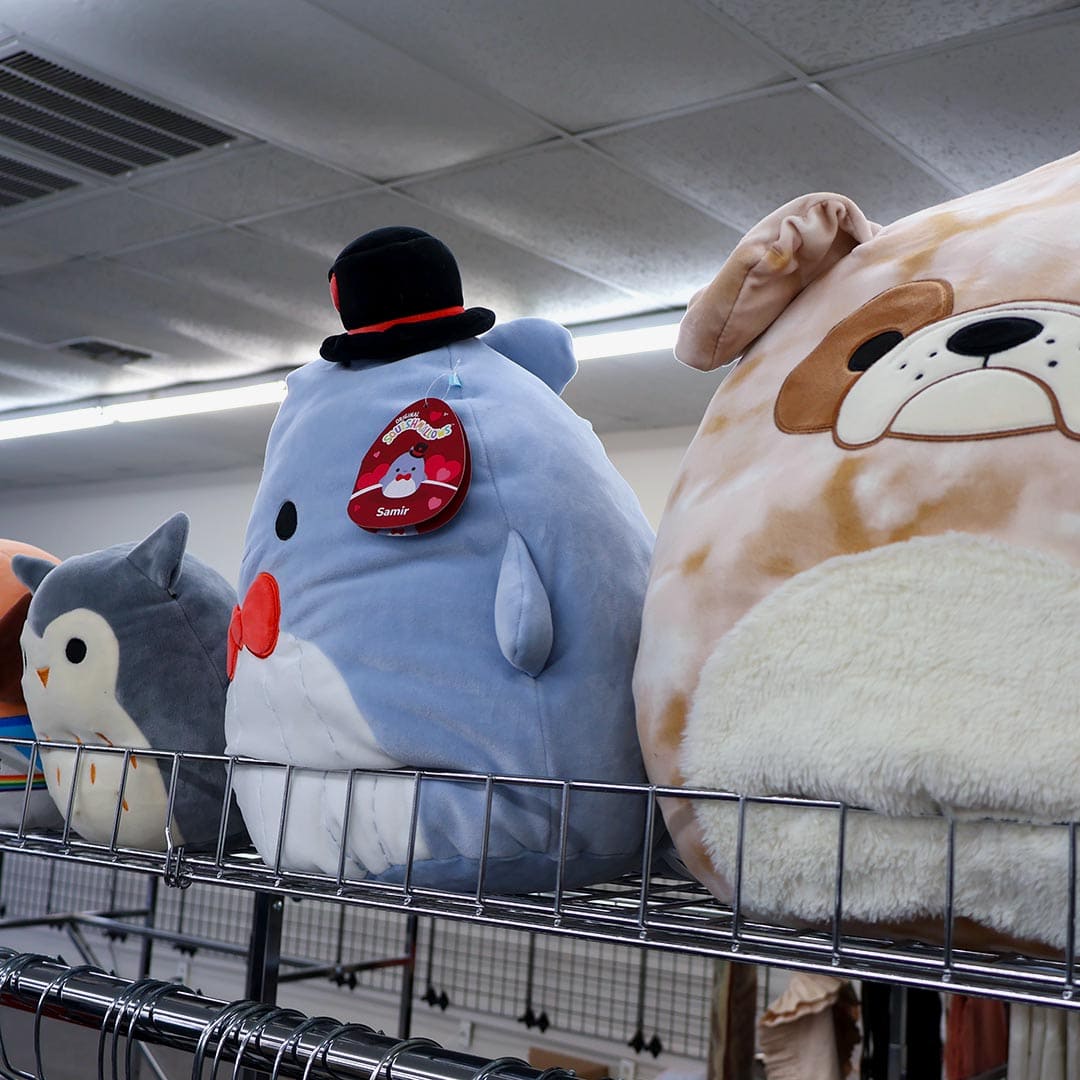 Plush toys on display shelf in store.